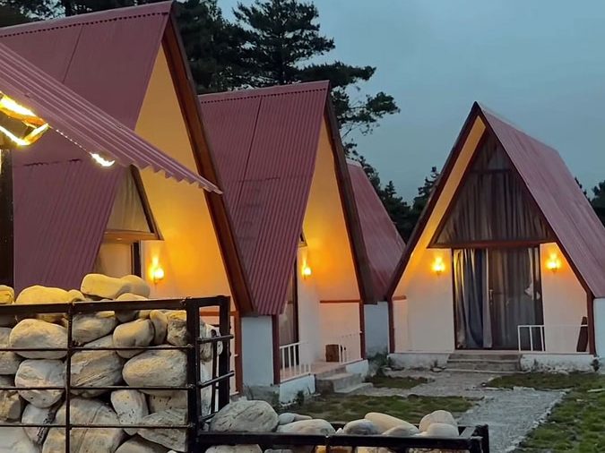 A-frame cottages glowing at dusk