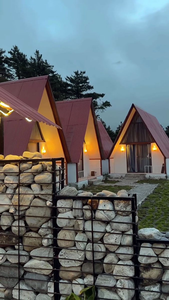 A-frame cottages glowing at dusk